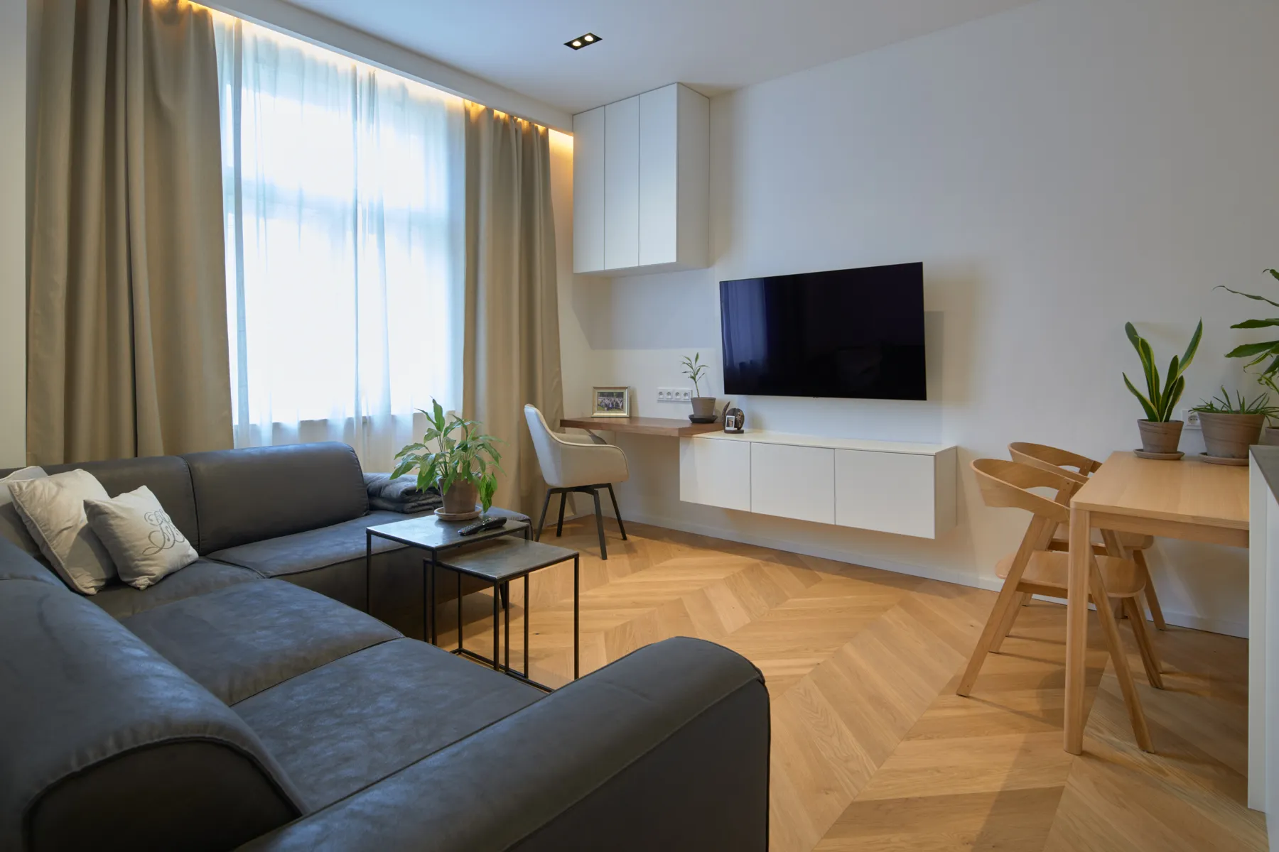 TV wall with floating cabinets and a walnut desk