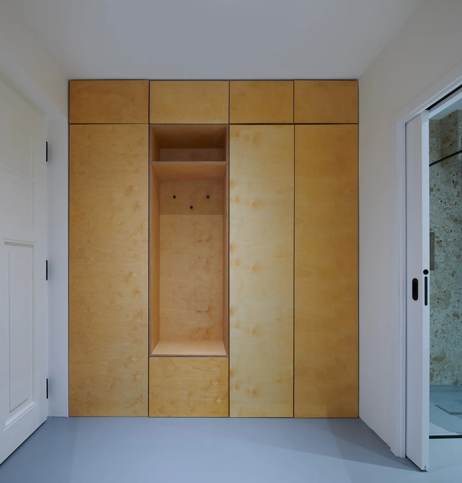 Built-in birch plywood wardrobe wall in the hallway