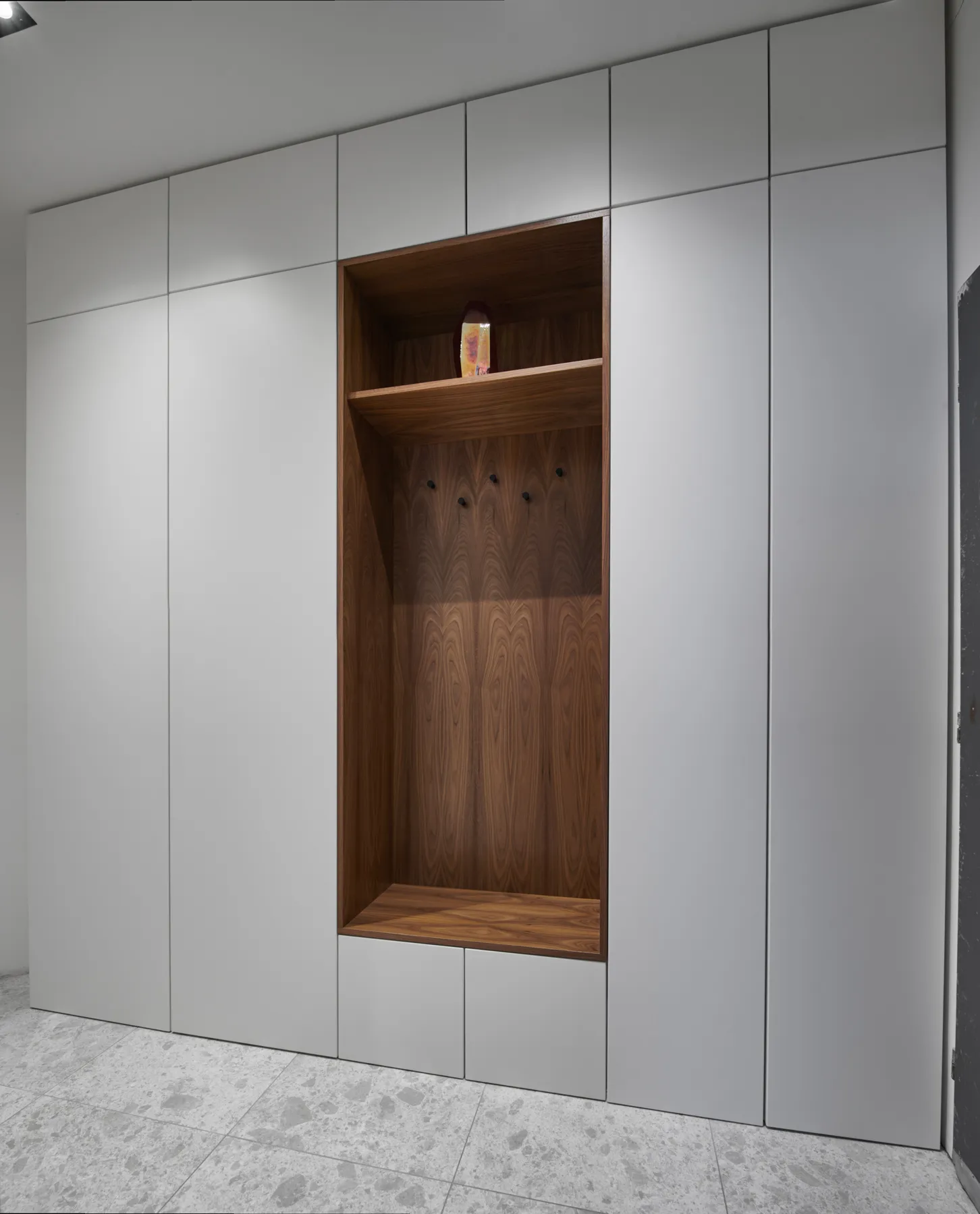 Built-in hallway wardrobe with a walnut coat niche
